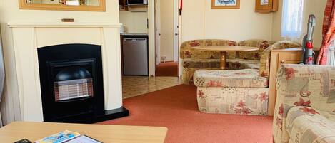 Un espacio habitable pequeño con chimenea, una mesa de comedor y un sofá.