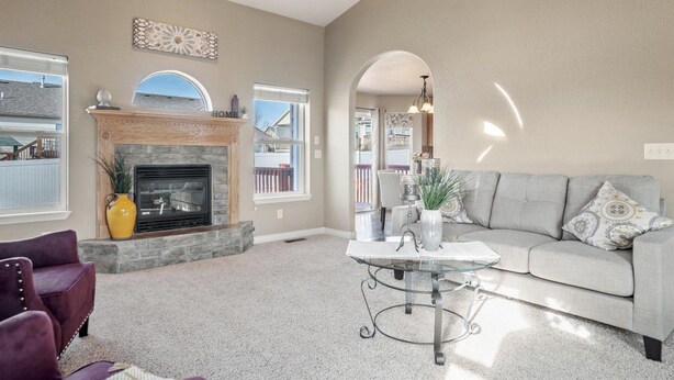 A spacious living room with a fireplace, a grey sofa, and a coffee table.