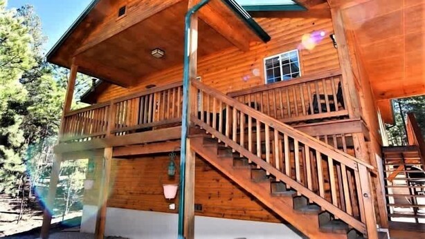 Una cabaña de madera con balcón y escalera.
