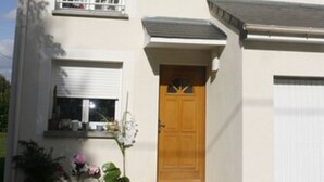 Ein zweistöckiges Gebäude mit Eingangstür, kleinem Balkon und Garage.