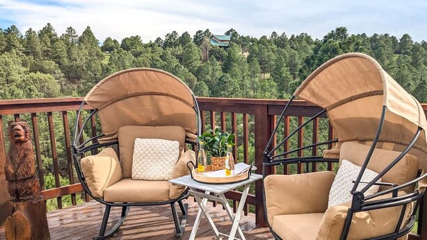 A deck with two beige cushioned chairs and a small table. - Spacious Mountain-Views with Game Room + Fireplace (Alto)