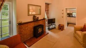 Ein Wohnzimmer mit Kamin, Fernseher und einer Couch.