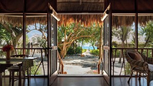 An open room with a view of a tree-lined path leading to a beach. - Turtle Inn by Francis Ford Coppola (Placencia)