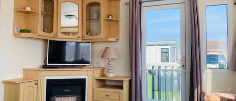 Mobile Home | Área de sala de estar | Televisión de pantalla plana, chimenea y reproductor de DVD