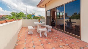 A balcony with a tiled floor, a round table, and four matching benches. - VIEWBOR VILLA - PATTAYA HOLIDAY HOUSE - WALKING STREET (Muang Pattaya)