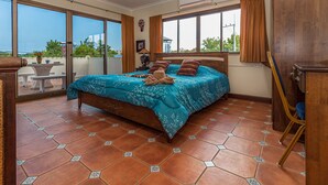 A bedroom with a large bed, a view of the outdoors, and a balcony with a table and chairs. - VIEWBOR VILLA - PATTAYA HOLIDAY HOUSE - WALKING STREET (Muang Pattaya)