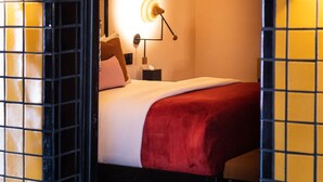 A hotel room with a bed, a nightstand, and a lamp. - Casa Hoyos (San Miguel de Allende)