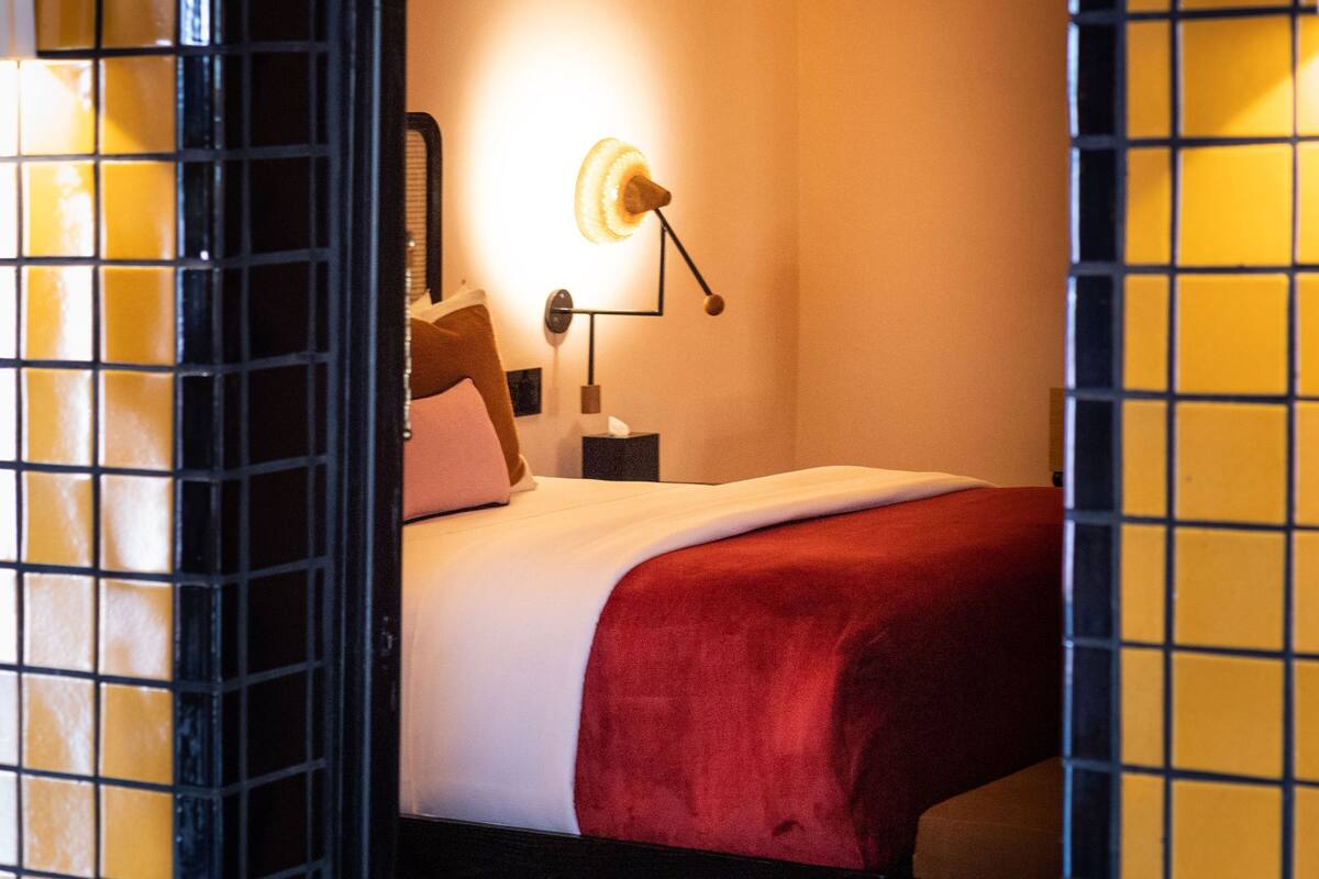 Ein Hotelzimmer mit einem Bett, einem Nachttisch und einer Lampe.