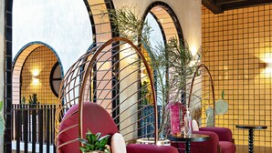 A modern interior with red chairs, a round table, and a striped rug. - Casa Hoyos (San Miguel de Allende)