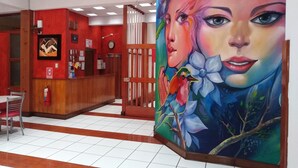 Un espace d’accueil avec un bureau en bois, une horloge et un mur rouge.
