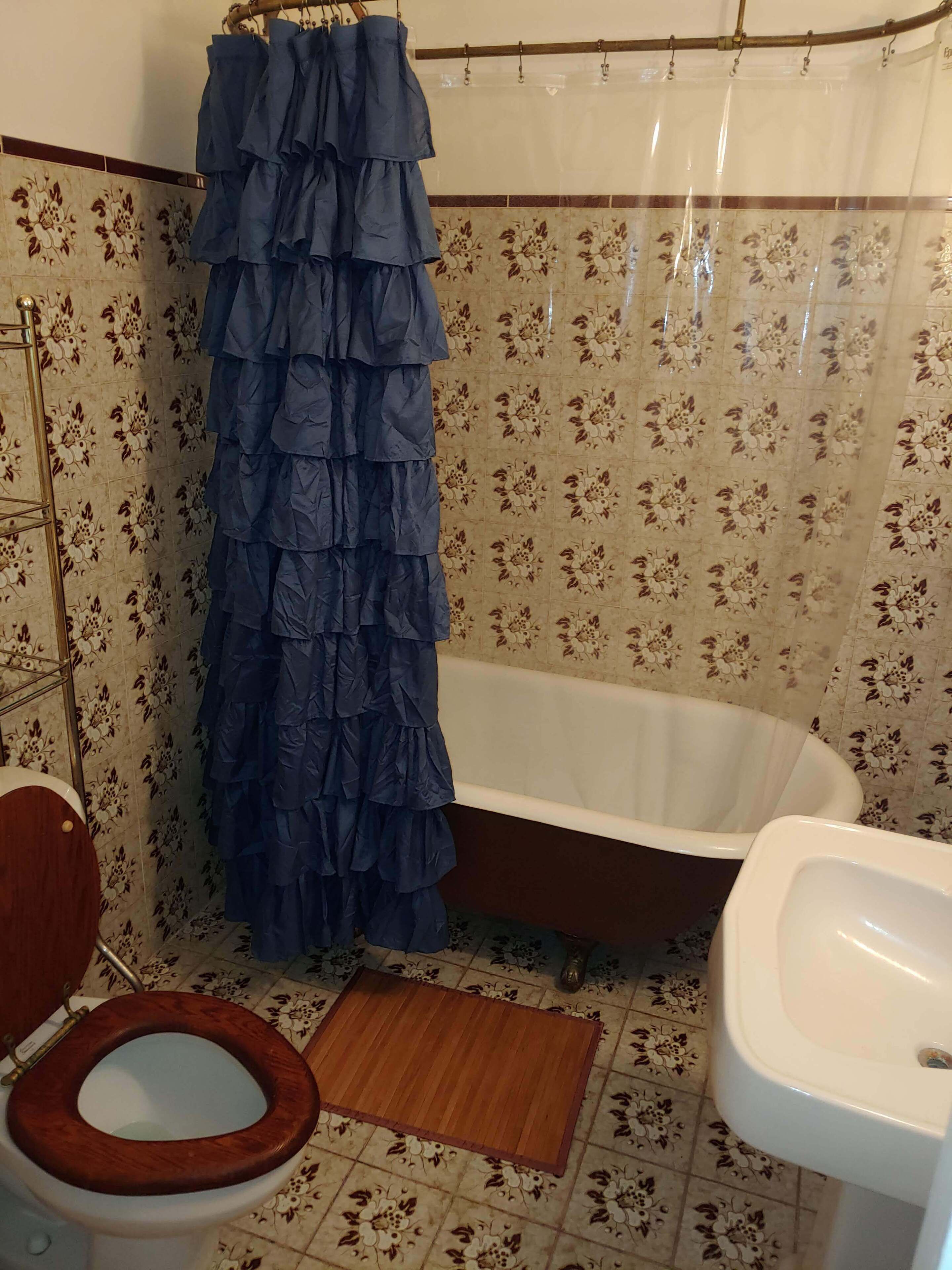 A bathroom with a wooden toilet, a white sink, and a bathtub.