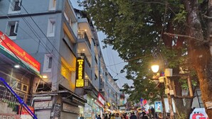 Een drukke straat met links een hotel genaamd "Hotel Hamers" en een restaurant "Maharaja Restaurant".