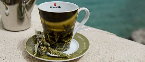 Una taza de té con tetera y platillo sobre una mesa.