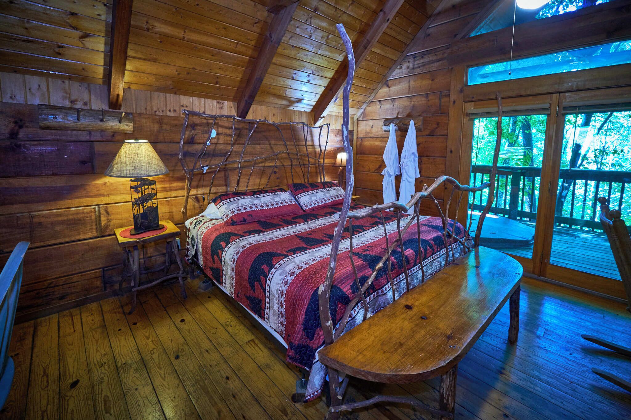 Una camera in legno dallo stile rustico con un letto, un tavolo e una lampada.