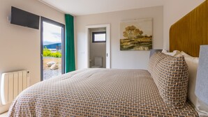 Un dormitorio con cama, un cuadro, un televisor y vistas a través de una puerta.