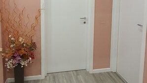 A hallway with a white door labeled "1", a "Happy" sign, and a decorative plant. - Il Giglio Guest House (Florence)