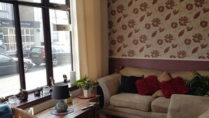 A living room with a beige sofa, a wooden coffee table, and a red rug. - Thornhill Blackpool (Blackpool)