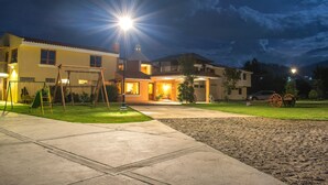 A residential house with a well-maintained lawn, a swing set, and a driveway leading to the entrance. - Hacienda Grande Hotel (San Cristóbal Totonicapán)