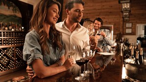 Eine Bar mit Holzwänden und einem Weinschränkchen im Hintergrund.