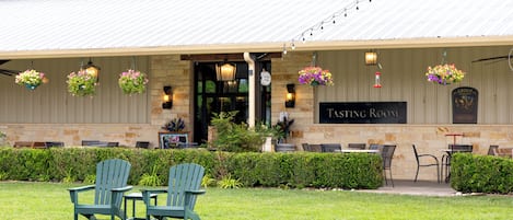 A building with a sign reading 'Fasting Room,' outdoor seating with chairs, and hanging flower baskets.