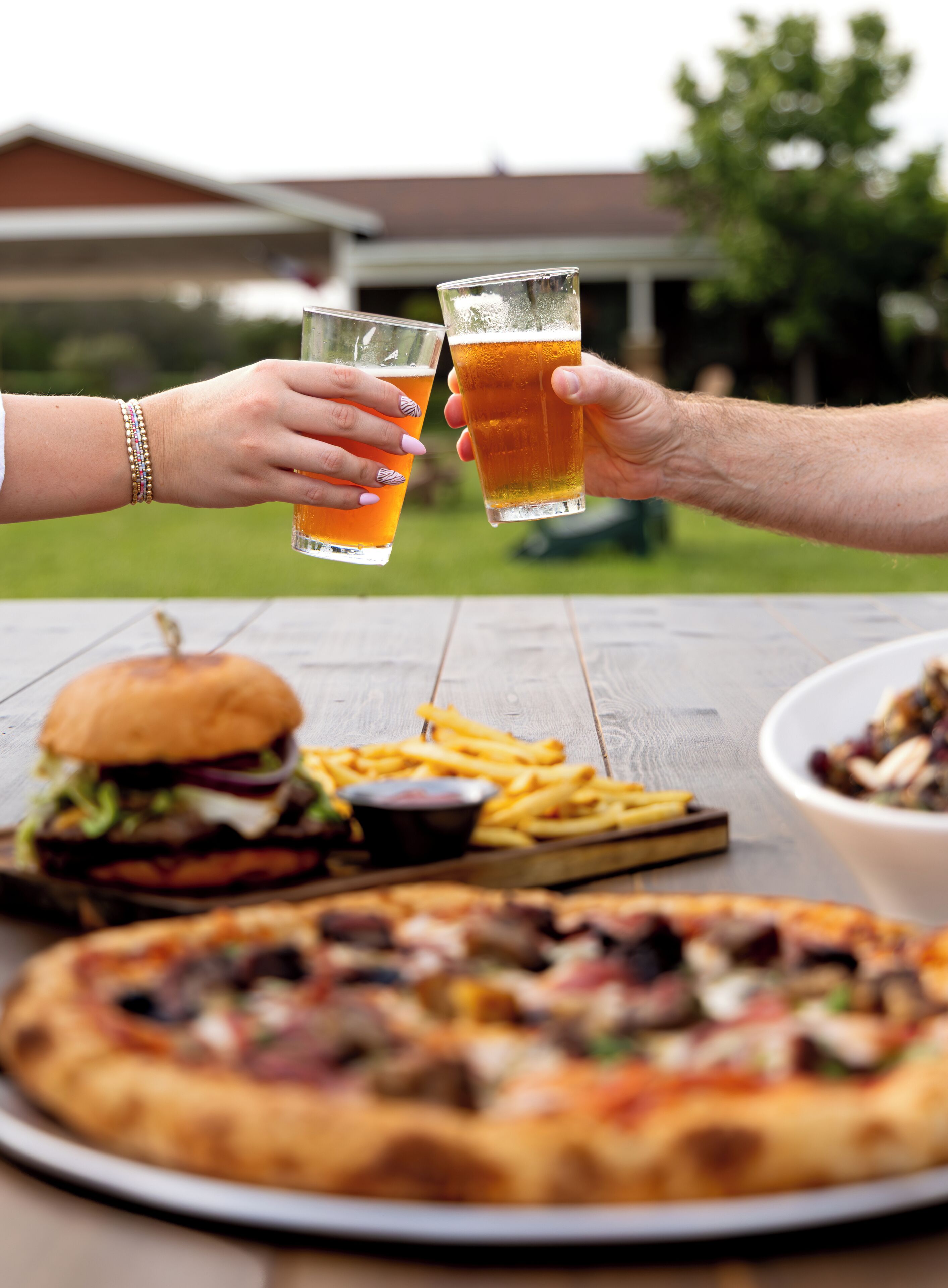 Ein Esstisch mit Pizza, Burger, Pommes und Salat.