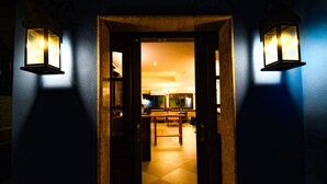 Una puerta que da a una habitación con piso de baldosas y una mesa con sillas.