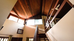 Una escalera con barandillas de madera y un techo con vigas de madera.