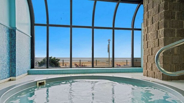 Ein Innenpool mit freiem Blick auf die Wüstenlandschaft durch große Fenster.