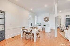 A spacious living area with a dining table and chairs, a fireplace, and a large mirror on the wall. - Huge 2 bedroom at North Beach with pool! (Tybee Island)