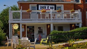 A two-story building with a balcony, outdoor seating, and a sign that reads "jack it up". - Distinctive Inns of Kingsville Inn31 (Kingsville)