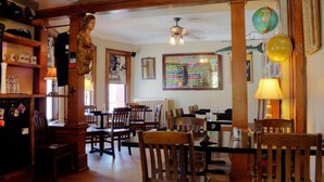 A cozy restaurant with wooden furniture, a chalkboard menu, and a globe decoration. - Distinctive Inns of Kingsville Inn31 (Kingsville)