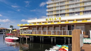 Ein Hotel direkt am Wasser mit einem Steg, auf dem sich mehrere Boote befinden, und einem Gebäude mit Balkonen.