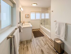 Bathtub, hair dryer, towels, toilet paper