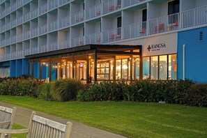 A hotel with a covered outdoor seating area, a blue exterior, and a sign for 'RANCSA.' - Sandy Toes, Zero Plans Required (Virginia Beach)