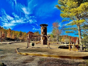 A playground with swings, a climbing structure, and a tower-like play area.