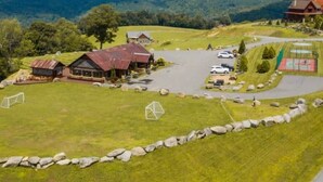 Una propietat rural amb diversos edificis, una zona d'aparcament i un camp esportiu.