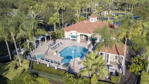 An aerial view of a resort with a swimming pool, lounge chairs, and palm trees. - "The Beauty", a SPLENDID Townhome Near Disney - Free WiFi, sleeps 8 comfortably! (Kissimmee)