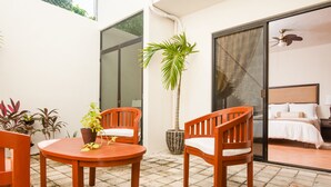 Una habitación con cama, ventilador de techo y vistas al exterior.