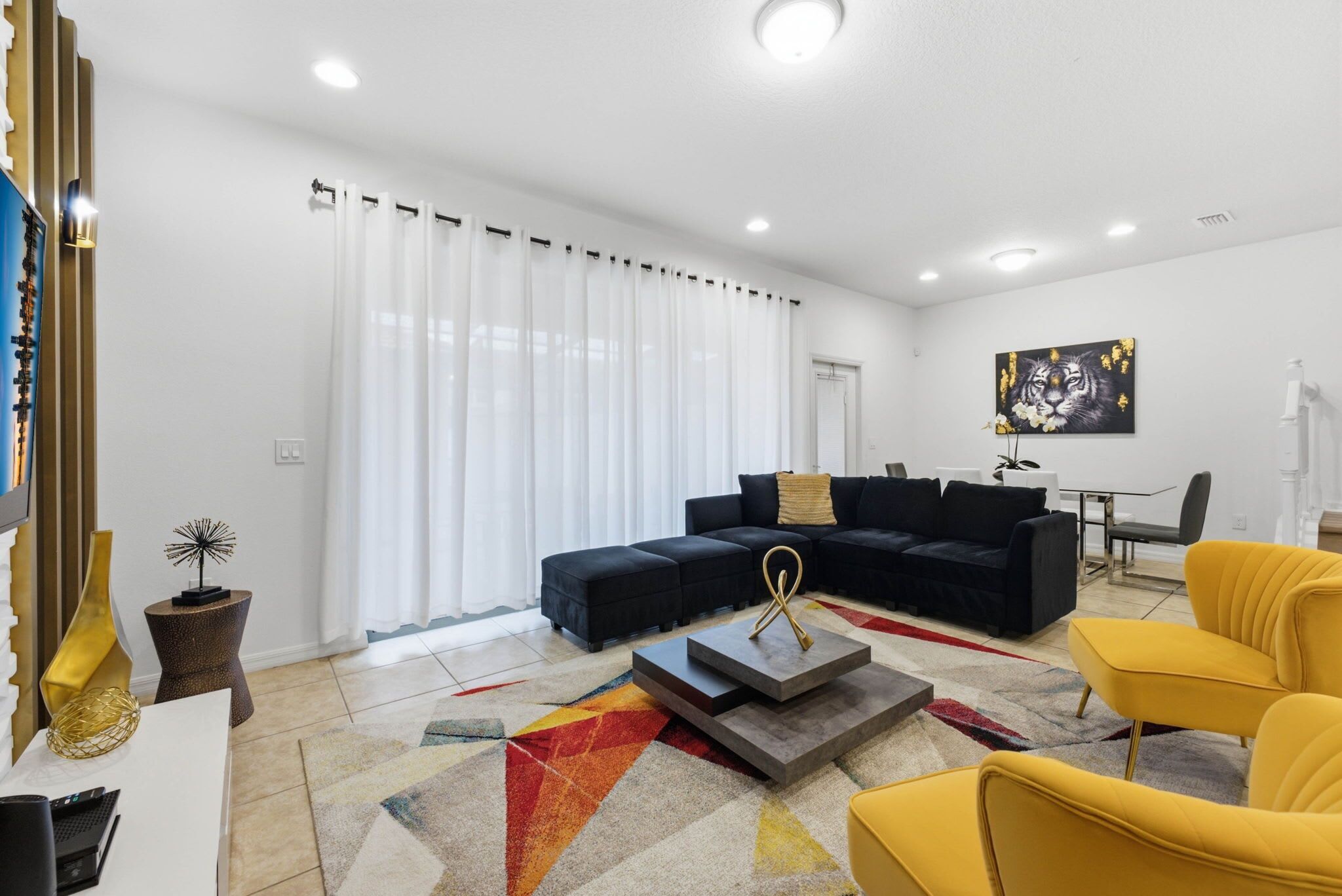 Un salon moderne avec un canapé d’angle, un fauteuil jaune et une table basse.