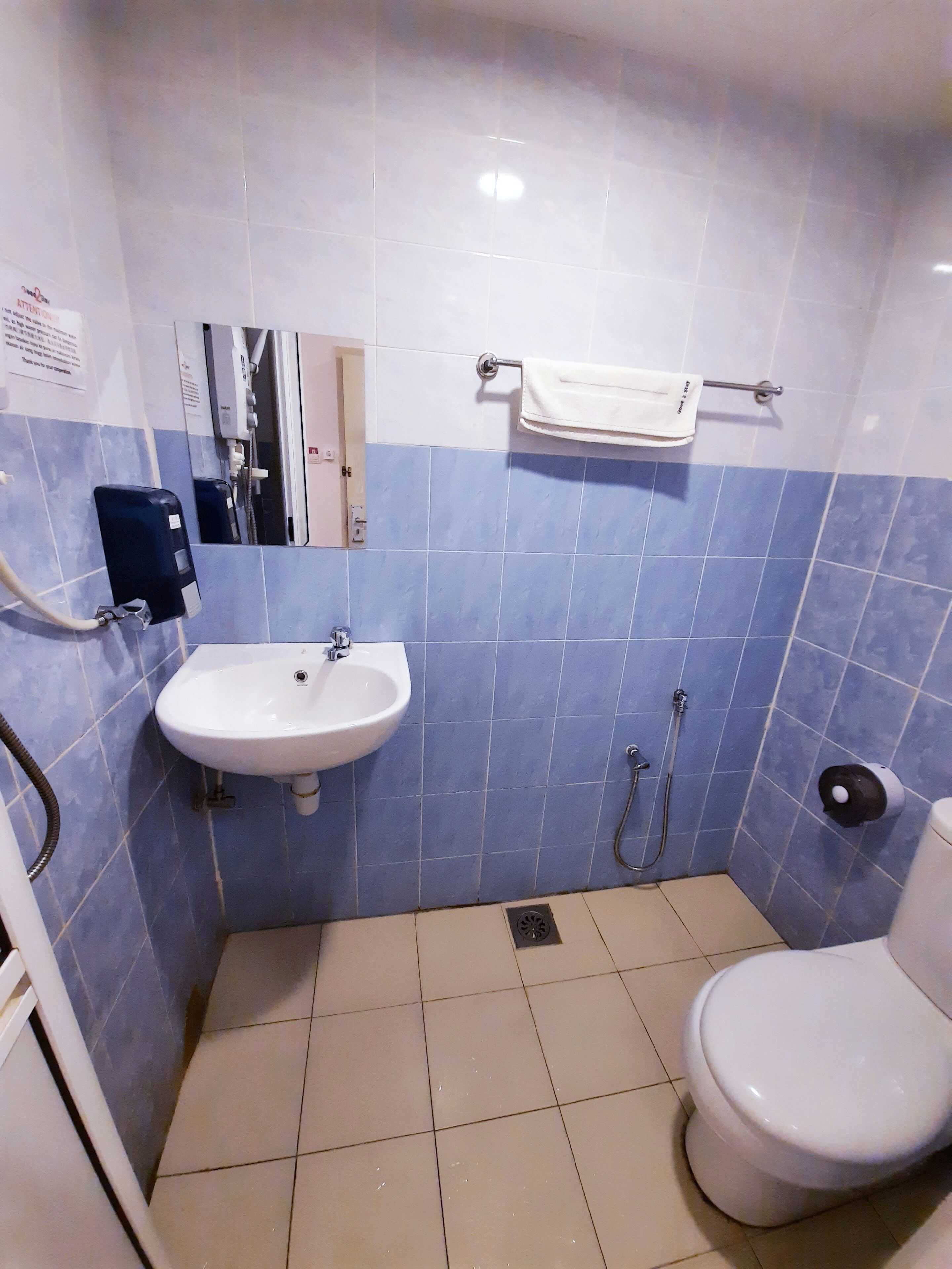 A bathroom with a sink, toilet, and hand dryer.