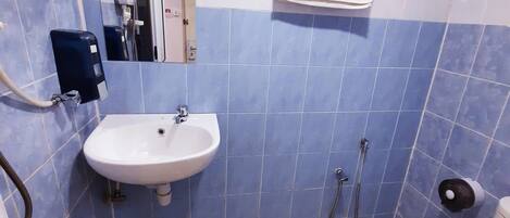 A bathroom with a sink, toilet, and hand dryer.