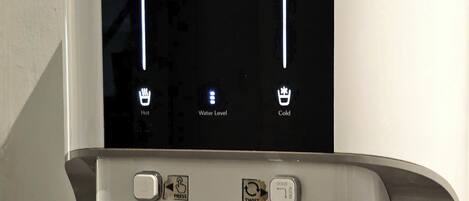 A water dispenser with a digital display, hot and cold water options, and a water level indicator.