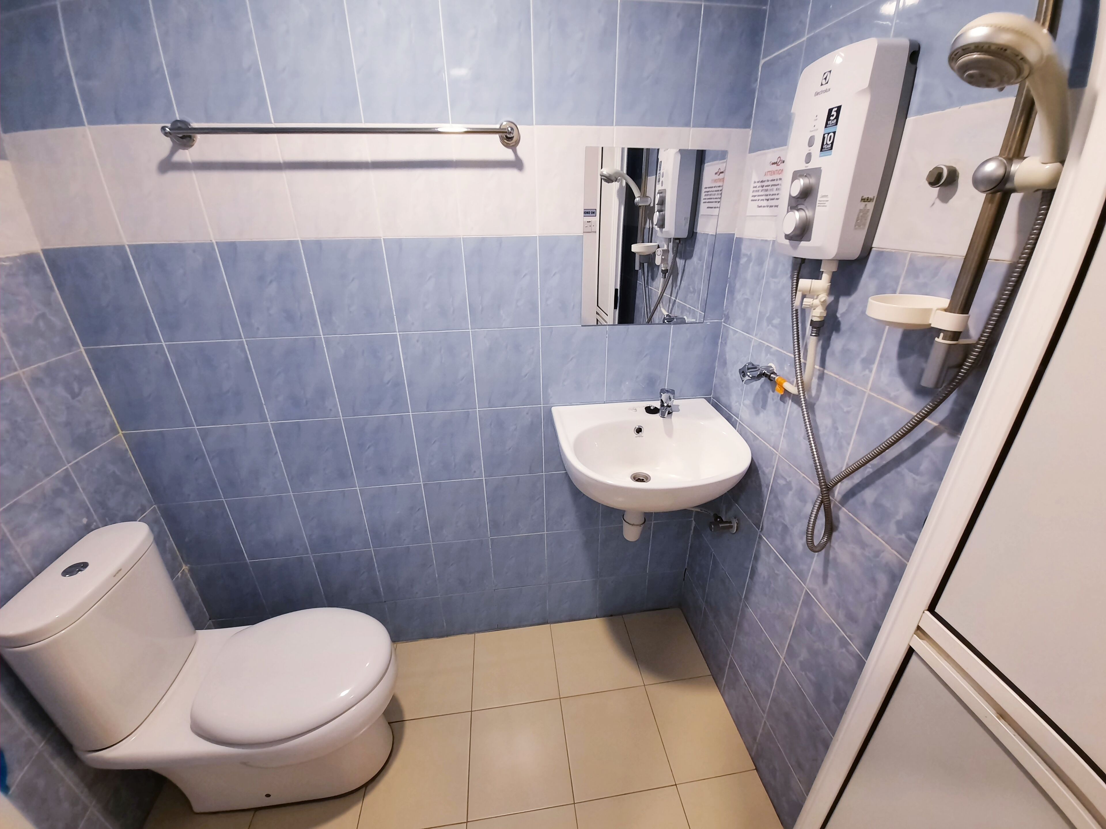 Un baño con inodoro, lavamanos y ducha.