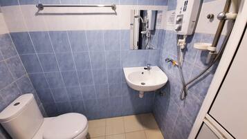 Un baño con inodoro, lavamanos y ducha.