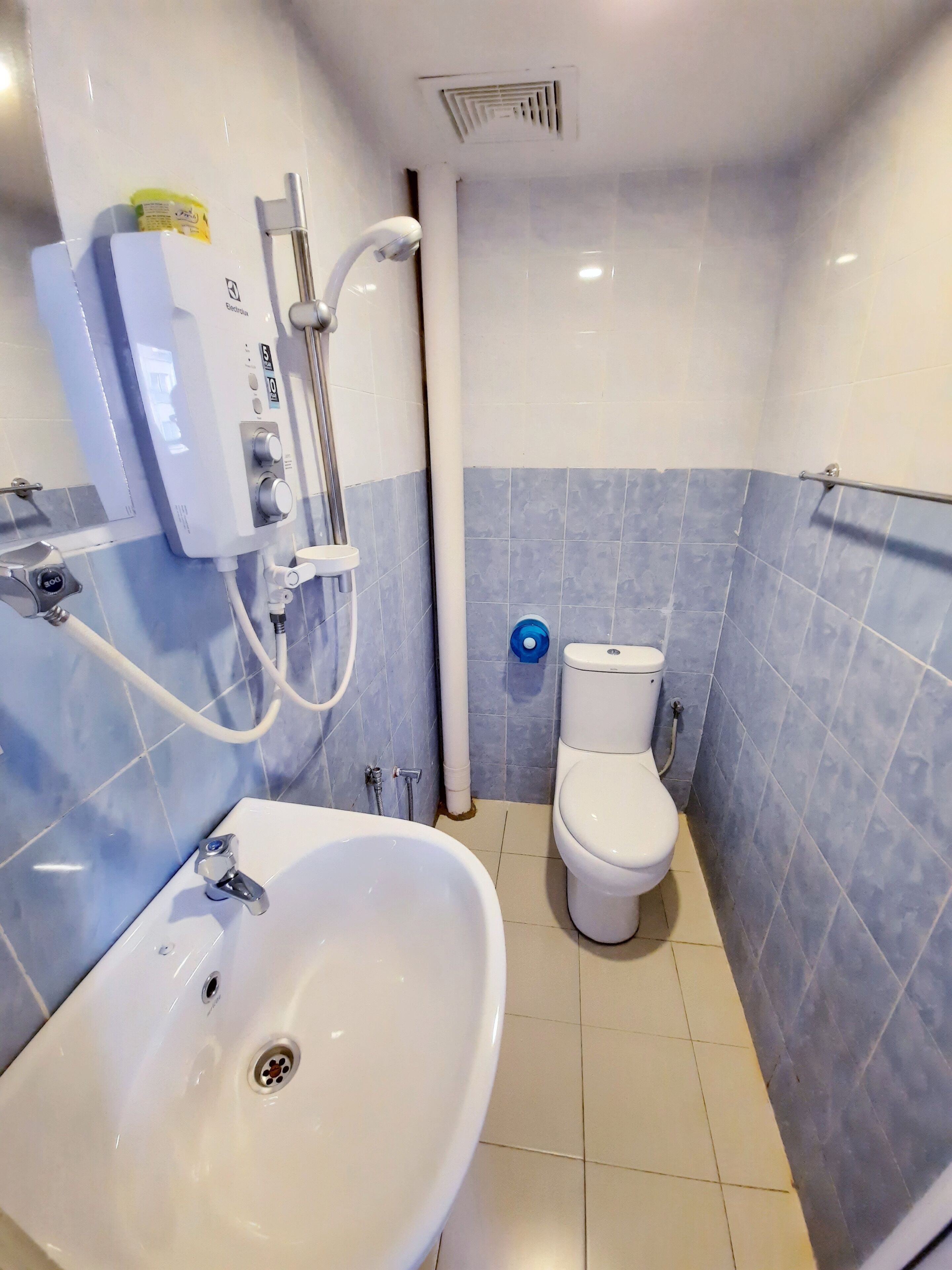 A bathroom with a white sink, a toilet, and a shower unit.