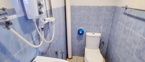 Un baño con lavamanos blanco, inodoro y cabina de ducha.