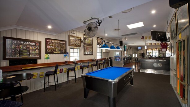 A pool table in a bar area with a bar counter and seating. - Lamington Hotel Motel (Maryborough)