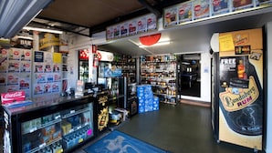 A liquor store with shelves stocked with various bottles and a display for Bundaberg Rum. - Lamington Hotel Motel (Maryborough)