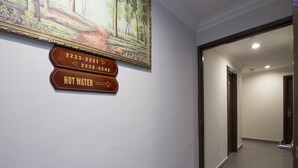 A hallway with a wooden sign indicating the direction to the hot water facility. - Valley View Hotel (Lumut)