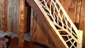 A wooden staircase with intricate lattice design, leading to an upper level.